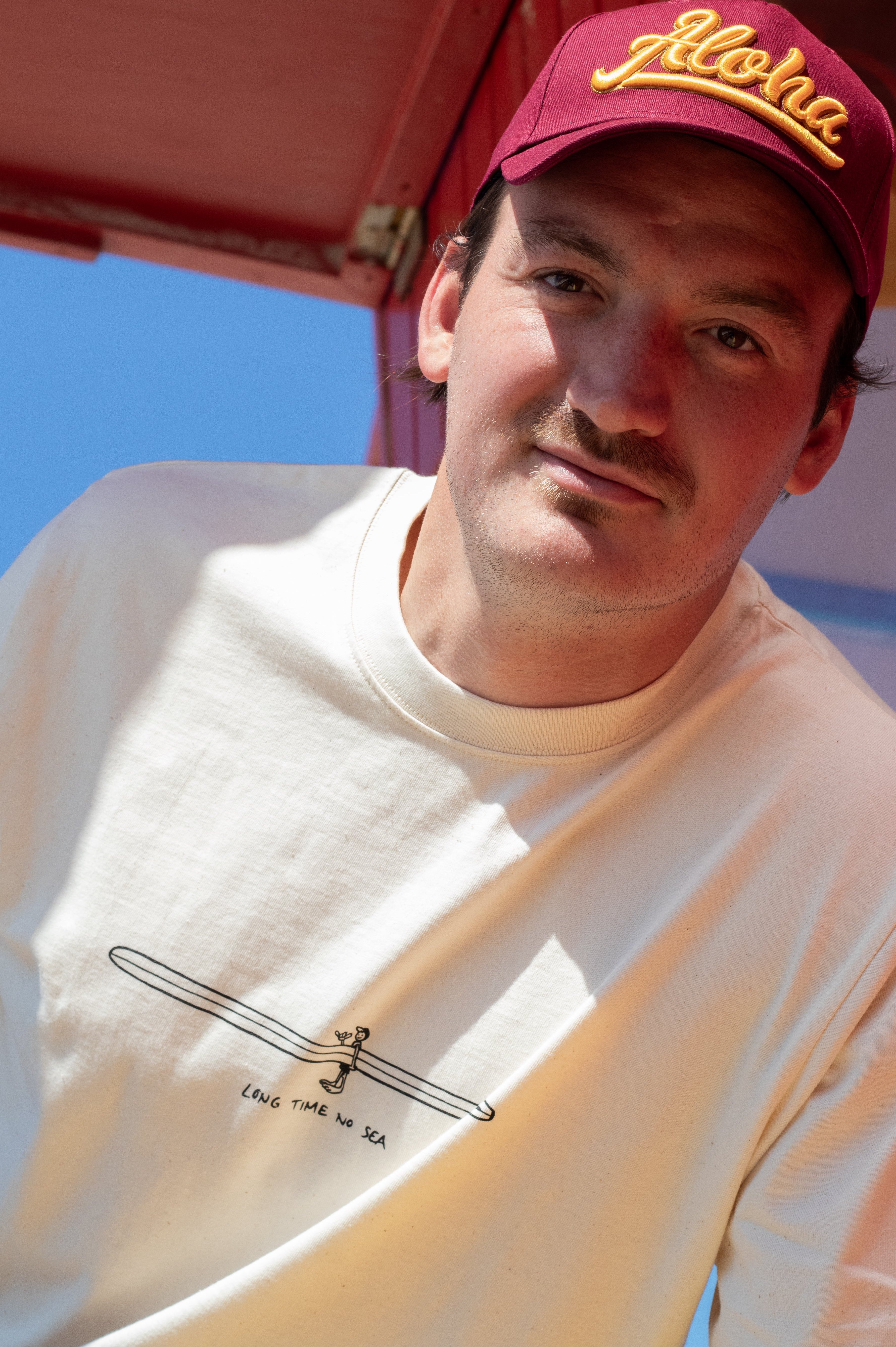 weißes T-Shirt mit Brustprint Long Time No Sea und Surfer mit Longboard